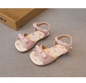 Detailed view of pink floral girls' sandals with sweet bow accent and soft sole