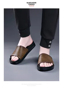Close-up of men's brown leather slides with black EVA foam soles worn with joggers