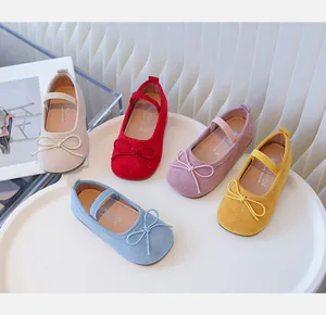 Group of colorful children's suede Mary Jane shoes with bows on white tray