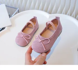 Close-up of pink suede girl's toddler shoes with bow-knot detail and elastic strap