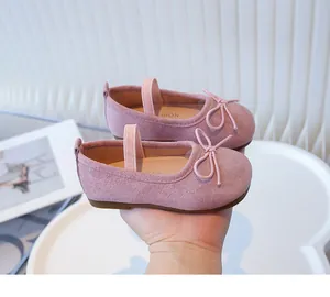 Detailed view of pink girls' soft-sole shoes featuring a decorative bow and elastic strap