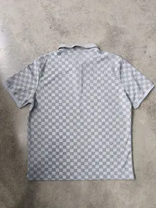 Vista posteriore di una polo da uomo pesante con motivo jacquard a scacchi grigi