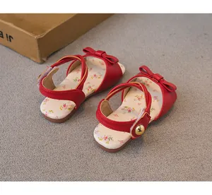 Detailed view of red toddler girl's sandals with floral insoles and bow accent