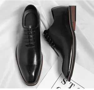 Close-up of black leather oxford dress shoes with square toe and brogue detailing.