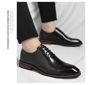 Close-up detail of classic black leather Oxford dress shoes with wingtip brogue pattern.