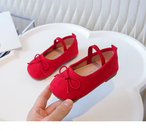 Close-up of red girls ballet flats with soft soles and decorative bow detailing.