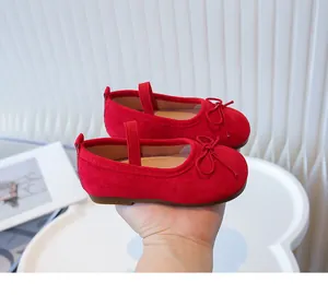 Close-up detail of red toddler ballet flats featuring cute bow and elastic strap.