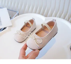 Macro view of beige toddler Mary Jane shoes featuring delicate bow and soft sole
