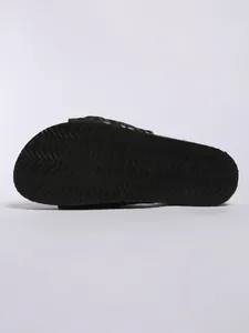 Detailed view of the anti-slip wavy texture on a black platform slide sandal sole
