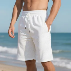 Detailed view of men's white jacquard textured shorts with a stylish beach backdrop