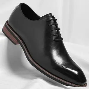 Classic black leather men's Oxford shoes with elegant brogue details on white fabric