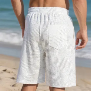 Detailed back view of men's white jacquard shorts showing heavy texture on the beach