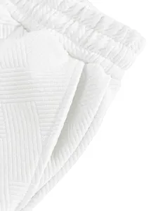 Close-up of white men's shorts showing heavy jacquard texture and side pocket detail
