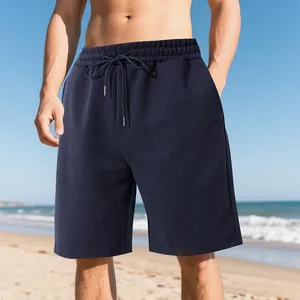 Detailed view of men's navy blue summer shorts with heavy jacquard texture on beach