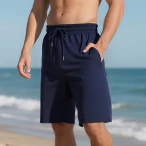 Close-up detail of men's navy blue summer shorts with jacquard texture on a beach