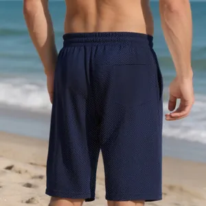 Close-up rear view of men's navy blue heavy jacquard textured shorts at a sunny beach