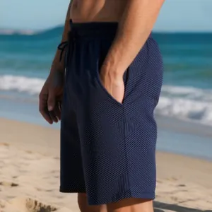Detailed view of men's navy blue heavy jacquard texture shorts against a beach backdrop.