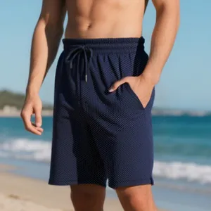 Detail view of men's navy blue jacquard texture shorts on beach
