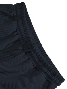 Detail of elastic waistband and heavy jacquard texture on navy shorts.