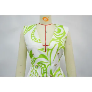 Detailopname van de groene bloemenprint op een witte mouwloze blazer met V-hals
