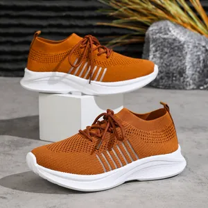 Detailansicht der orangen Fly-Knit-Plateau-Sneaker für Damen mit dicken weißen Sohlen.