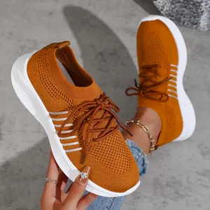 Nahaufnahme von orangefarbenen Fly-Woven-Sneakern mit weißen Plateausohlen.