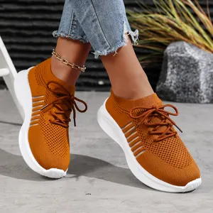 Detailansicht der atmungsaktiven orangefarbenen Strick-Sneaker mit Plateausohle für den Sommer.