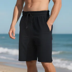 Close-up of heavy jacquard texture on men's black drawstring shorts against a beach scene