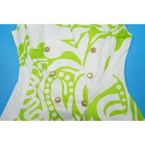 Detailopname van een stijlvol groen-wit bedrukt vest met vintage gouden knopen