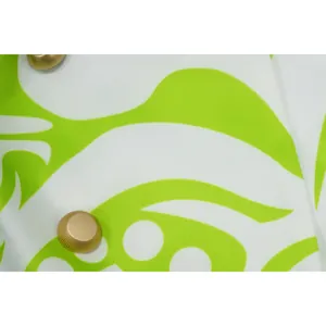 Detail van de groen-witte bedrukte stof met gouden knopen op het modieuze blazerpak