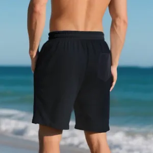 Back view of men's black jacquard textured high street hip hop shorts on beach