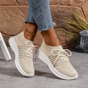 Nahaufnahme von beigen Fly-Knit-Sneakern mit klobigen weißen Plateausohlen