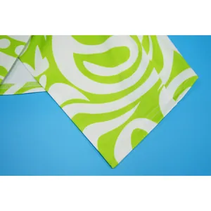 Close-up van de limoengroene stof met abstracte wervelprint en zoomstiksels