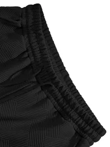 Macro detail of men's black shorts featuring premium jacquard texture and waistband