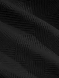 Macro detail of black heavy jacquard fabric with high-street textured pattern