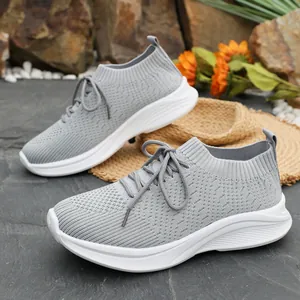 Detailansicht grauer fliegender gewebter Sneaker mit bequemen weißen Plateausohlen