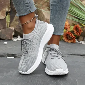 Nahaufnahme modischer grauer Damen-Sneaker mit Plateausohle und Fly-Knit-Gewebe