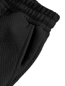 Close-up macro view of the textured jacquard fabric and pocket on black high-street shorts.