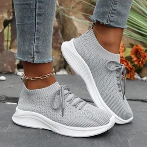 Nahaufnahme von grauen Damen-Flyknit-Sneakern mit weißer Plateausohle im Freien