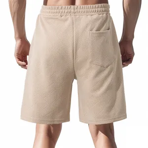 Detailed back view of men's summer shorts with heavy jacquard geometric texture in beige.