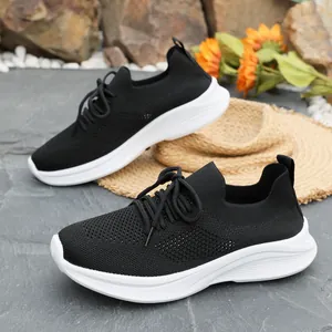 Nahaufnahme schwarzer atmungsaktiver Fly-Knit-Sneaker mit dicker weißer Plateausohle