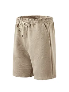 Detailed view of men's beige textured jacquard shorts with drawstring waist.