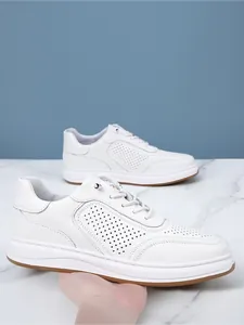Detailed side view of breathable white perforated leather sneakers for men with no-tie laces