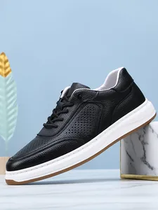 Detailed side view of breathable black leather men's sneakers with perforated pattern