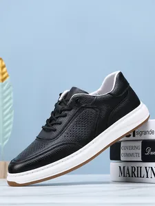 Detailed side view of breathable black pebble-grain leather sneaker on decorative books