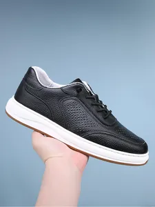 Detail view of men's black pebble grain leather sneakers with breathable hole patterns