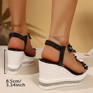 Side view of high heel 8.5cm rhinestone wedge sandals with black floral strap details