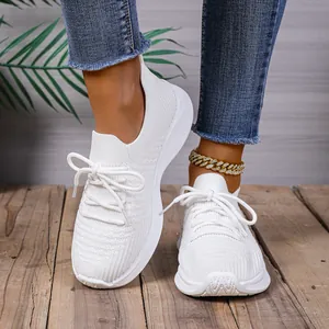 Modische weiße Fly-Knit Plateau-Sneaker für Damen, am Fuß mit Jeans präsentiert