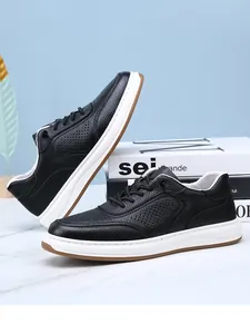 Close-up of black breathable leather sneakers with pebbled texture and white sole.