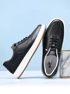 Detailed macro shot of men's breathable black cowhide leather sneakers with perforated design.